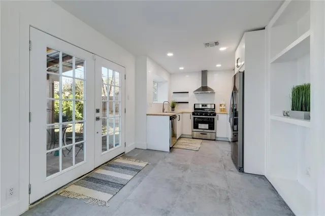 a view of a kitchen with refrigerator and window