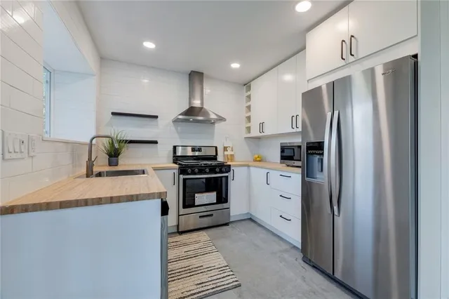a kitchen with stainless steel appliances a refrigerator sink and stove