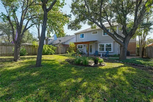 a view of a house with backyard and a tree