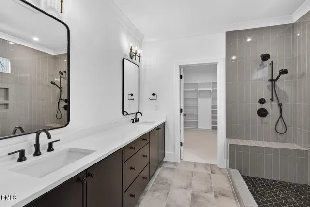 a bathroom with a double vanity sink mirror and shower