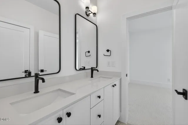 a bathroom with double sink and a mirror