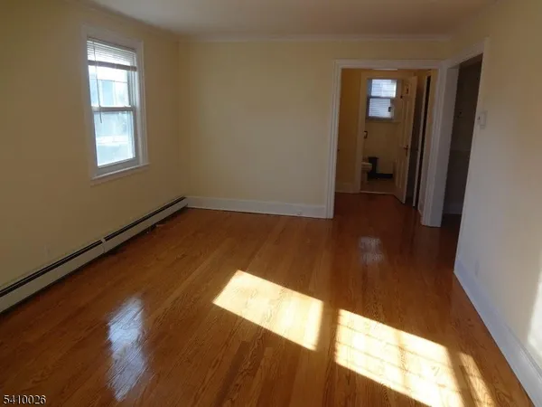 a view of a room with wooden floor and a window