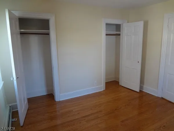 an empty room with wooden floor and closet