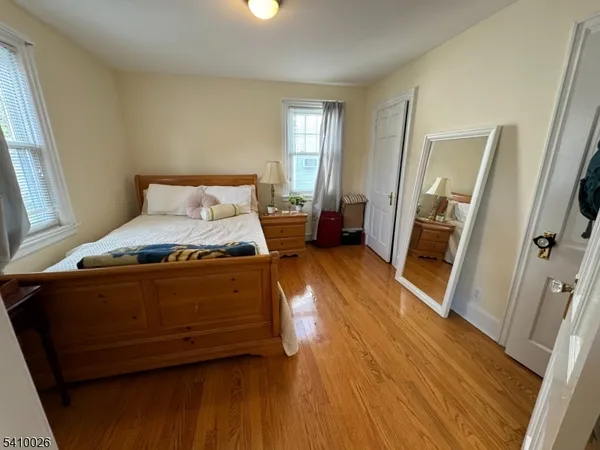 a spacious bedroom with a bed and wooden floor