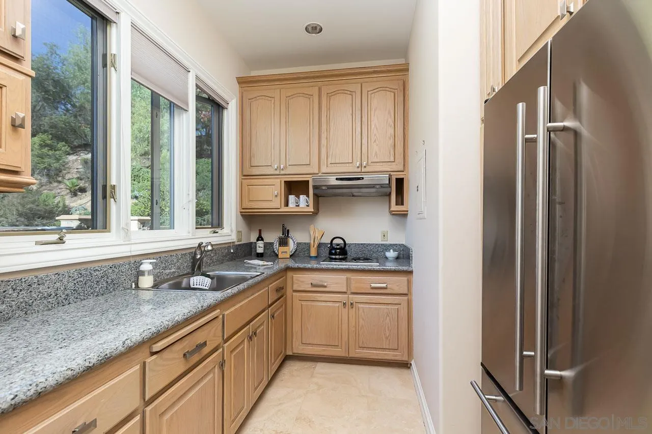 14440 Ridge Ranch Road Valley Center, CA 92082 - Photo 50 of 74 a kitchen with stainless steel appliances granite countertop a sink stove and cabinets
