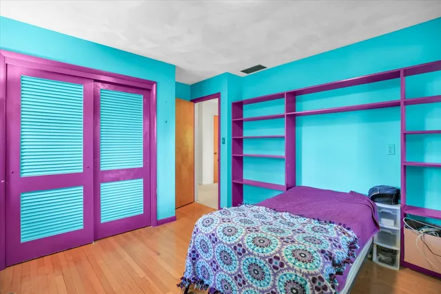 a bedroom with a bed and a dresser next to a window