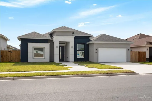 a view of a house with a yard and large tree