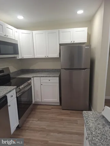 a kitchen with a refrigerator sink and cabinets