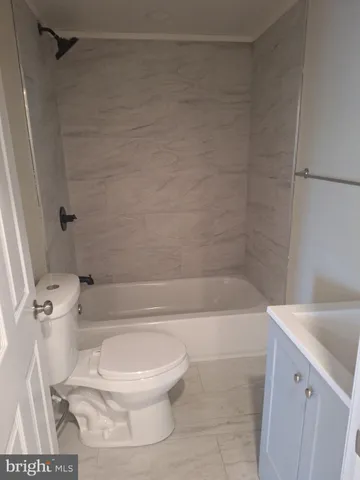 a white toilet sitting next to a bath tub