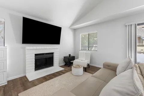 a living room with furniture a flat screen tv and a fireplace