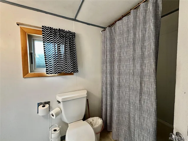 a bathroom with a toilet and a shower curtain