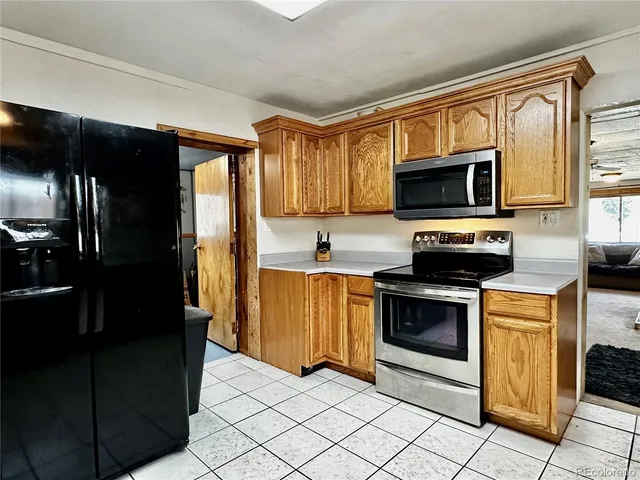 a kitchen with stainless steel appliances granite countertop a refrigerator and a stove top oven