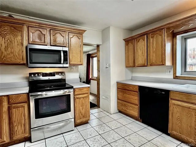 a kitchen with granite countertop a stove microwave and refrigerator
