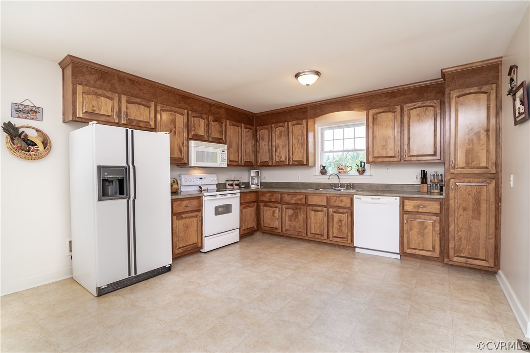 17127 Loving Union Road Disputanta, VA 23842 - Photo 9 of 26 a kitchen with a refrigerator a sink and cabinets
