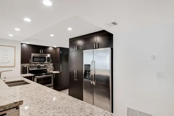 a kitchen with cabinets stainless steel appliances and wooden floor
