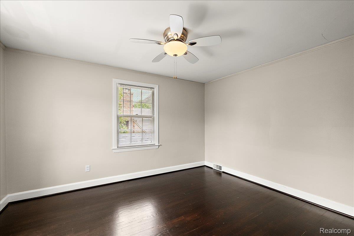 1051 Devonshire Road Grosse Pointe, MI 48230 - Photo 54 of 99 Room featuring a ceiling fan with integrated lighting, a double-hung window with white trim, dark wood-finish flooring, and white baseboards