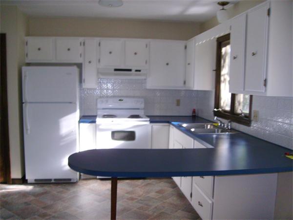 288 Mill Road Fairhaven, MA 02719 - Photo 10 of 22 a kitchen with kitchen island granite countertop a sink a stove and white cabinets