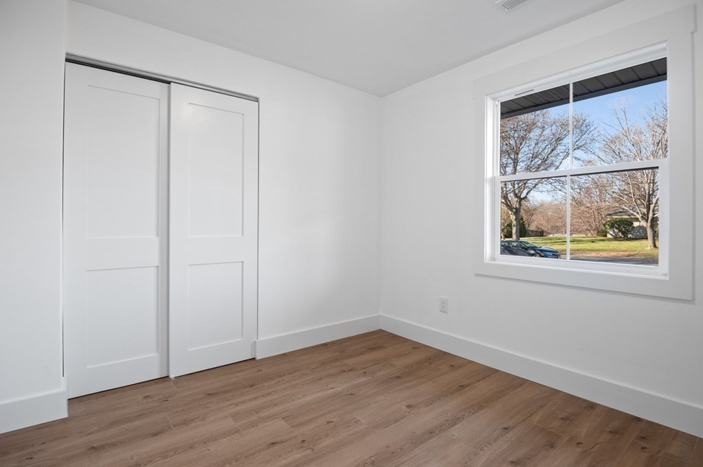 27 Trinity Street Danvers, MA 01923 - Photo 13 of 27 a view of an empty room with wooden floor and window