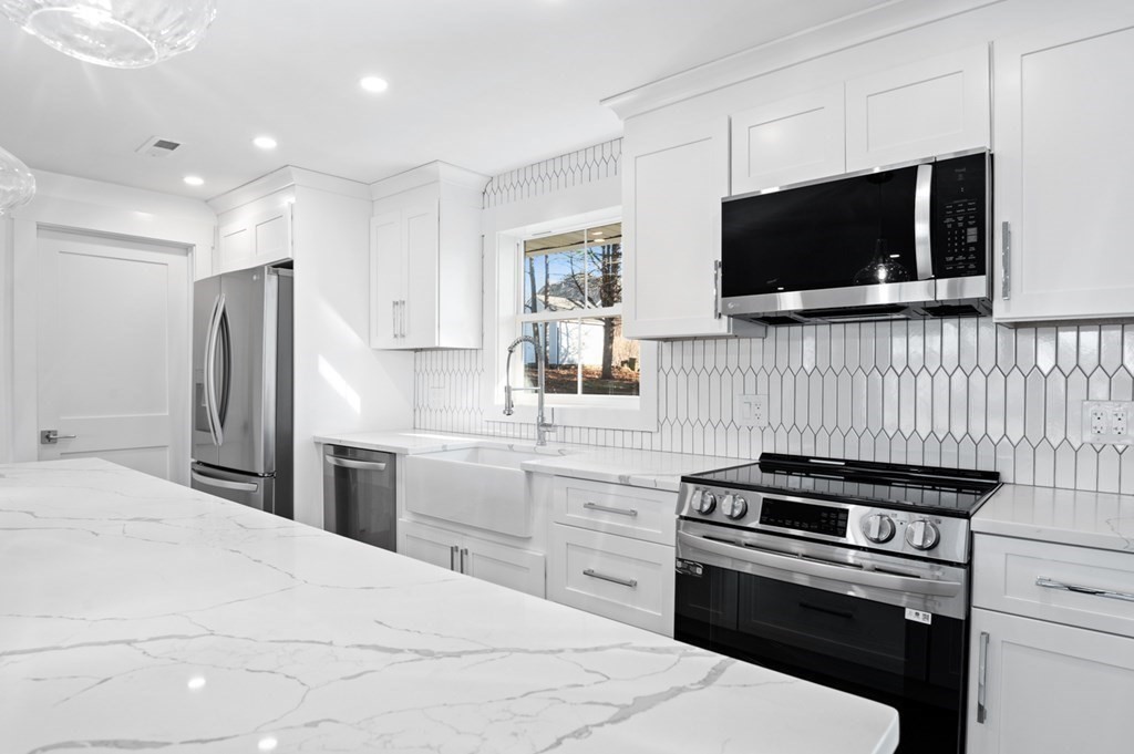 27 Trinity Street Danvers, MA 01923 - Photo 3 of 27 a kitchen with stainless steel appliances a stove microwave and refrigerator