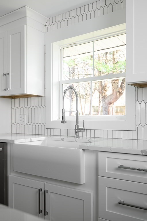 27 Trinity Street Danvers, MA 01923 - Photo 4 of 27 a bathroom with a sink and a large mirror next to a window