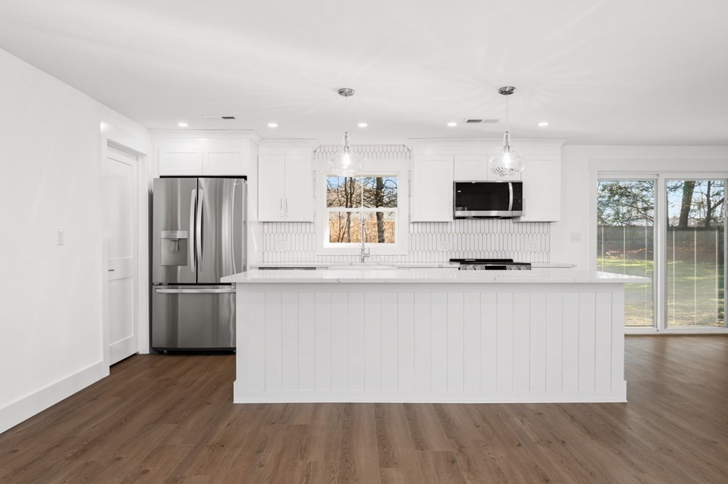 27 Trinity Street Danvers, MA 01923 - Photo 5 of 27 a large kitchen with stainless steel appliances a large counter top a stove and a refrigerator