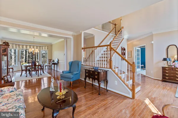 a view of a dining room and livingroom with furniture wooden floor a chandelier
