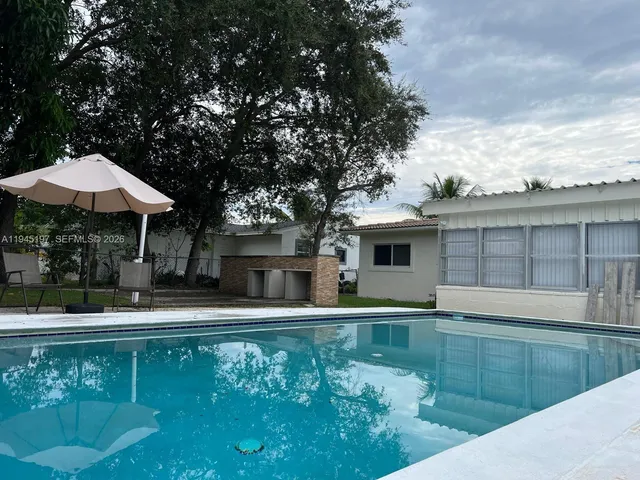 a view of a swimming pool with a patio and a yard