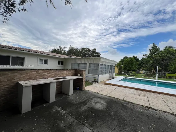 a backyard of a house with barbeque oven table and chairs