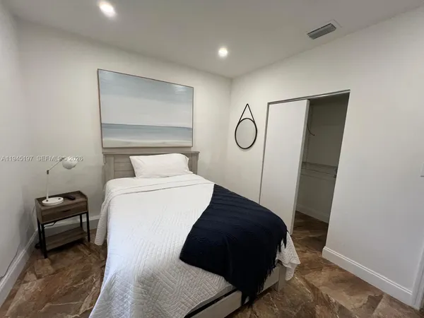 a bedroom with a bed and a flat screen tv