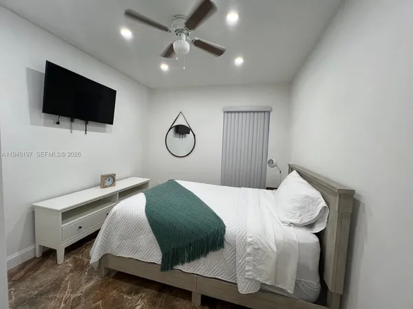 a bedroom with a bed and a ceiling fan