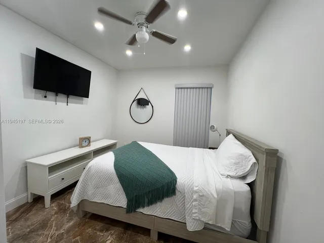 a bedroom with a bed and a ceiling fan