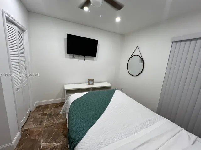 a bedroom with a bed and a flat screen tv