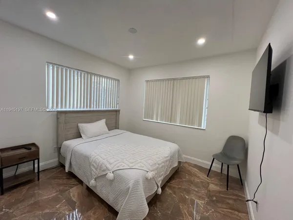 a bedroom with a bed and a flat screen tv