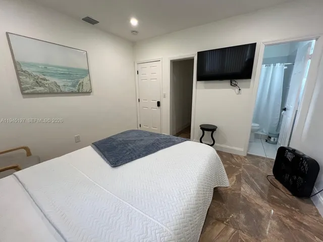 a bedroom with a bed and a flat screen tv