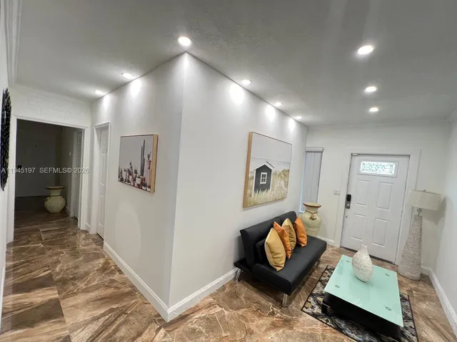 a view of a dining room with furniture a kitchen and wooden floor