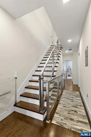 a view of a hallway with stairs and wooden floor