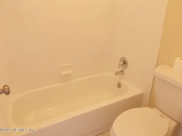 a bathroom with a toilet and a bathtub