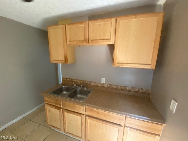 921 Rudyard Road Cleveland, OH 44110 - Photo 24 of 31 Kitchen featuring brown cabinets and light tile floors