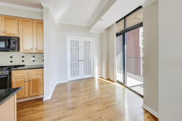a view of a kitchen with wooden floor and a window