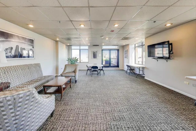 a living room with stainless steel appliances furniture a dining table and kitchen view