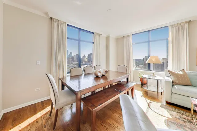a living room with a couch and a dining table with wooden floor