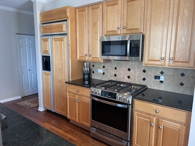 a kitchen with stainless steel appliances granite countertop white cabinets and a stove