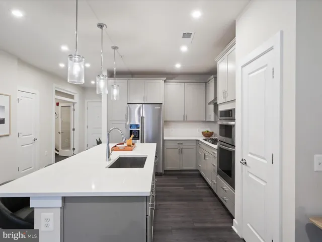 a large kitchen with a lot of counter space and wooden floor