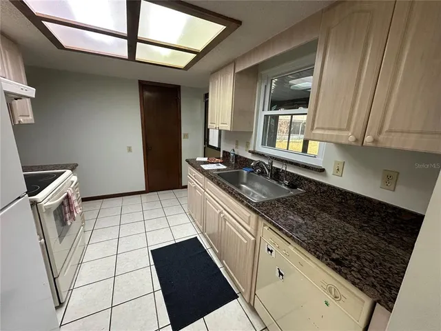 a kitchen with a sink a stove and cabinets