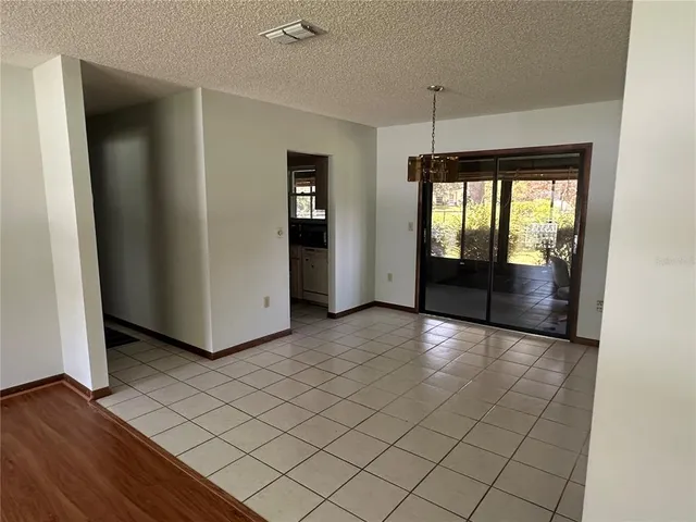 a view of a refrigerator in kitchen and entryway with wooden floor