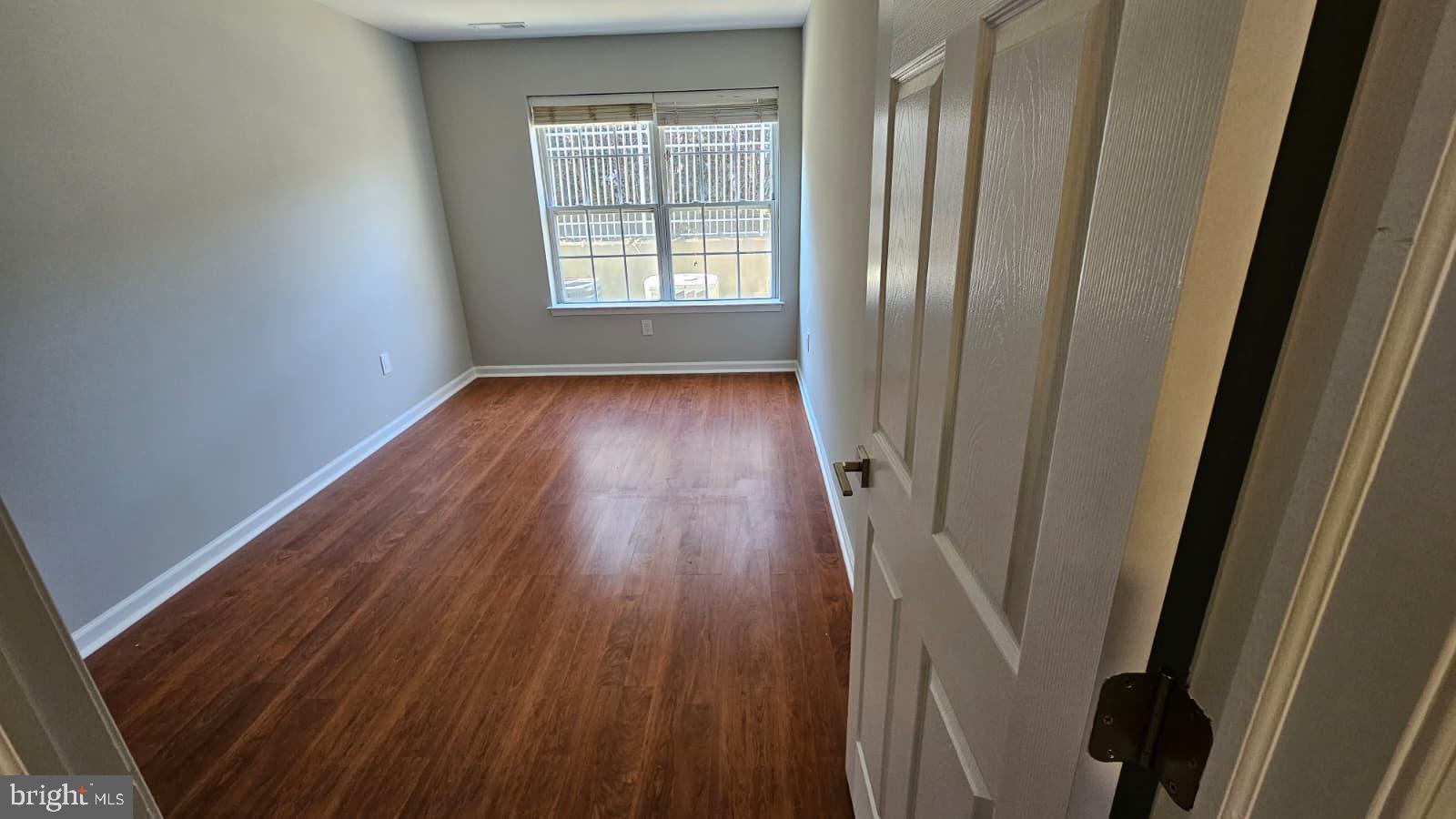 9228-38 Blue Grass Road, Unit 27 Philadelphia, PA 19114 - Photo 3 of 15 a view of an empty room with wooden floor and a window