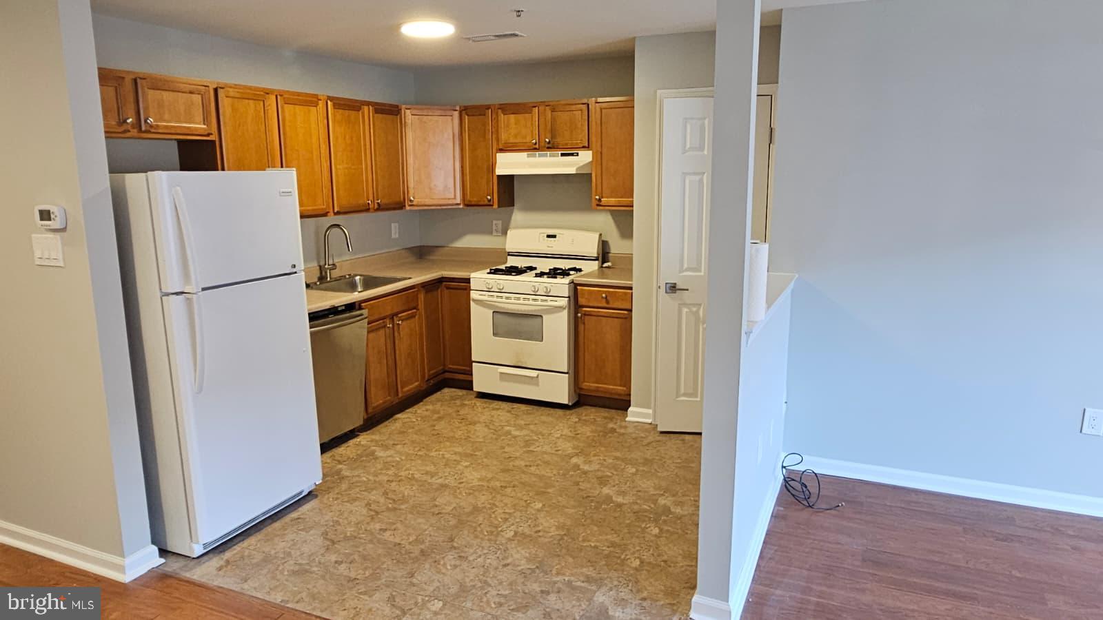 9228-38 Blue Grass Road, Unit 27 Philadelphia, PA 19114 - Photo 4 of 15 a kitchen with a refrigerator sink stove and cabinets