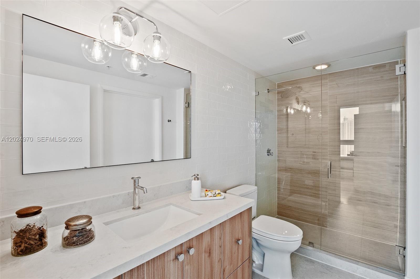 90 Southwest 3rd Street, Unit 3810 Miami, FL 33130 - Photo 25 of 45 a bathroom with a sink toilet a mirror and shower