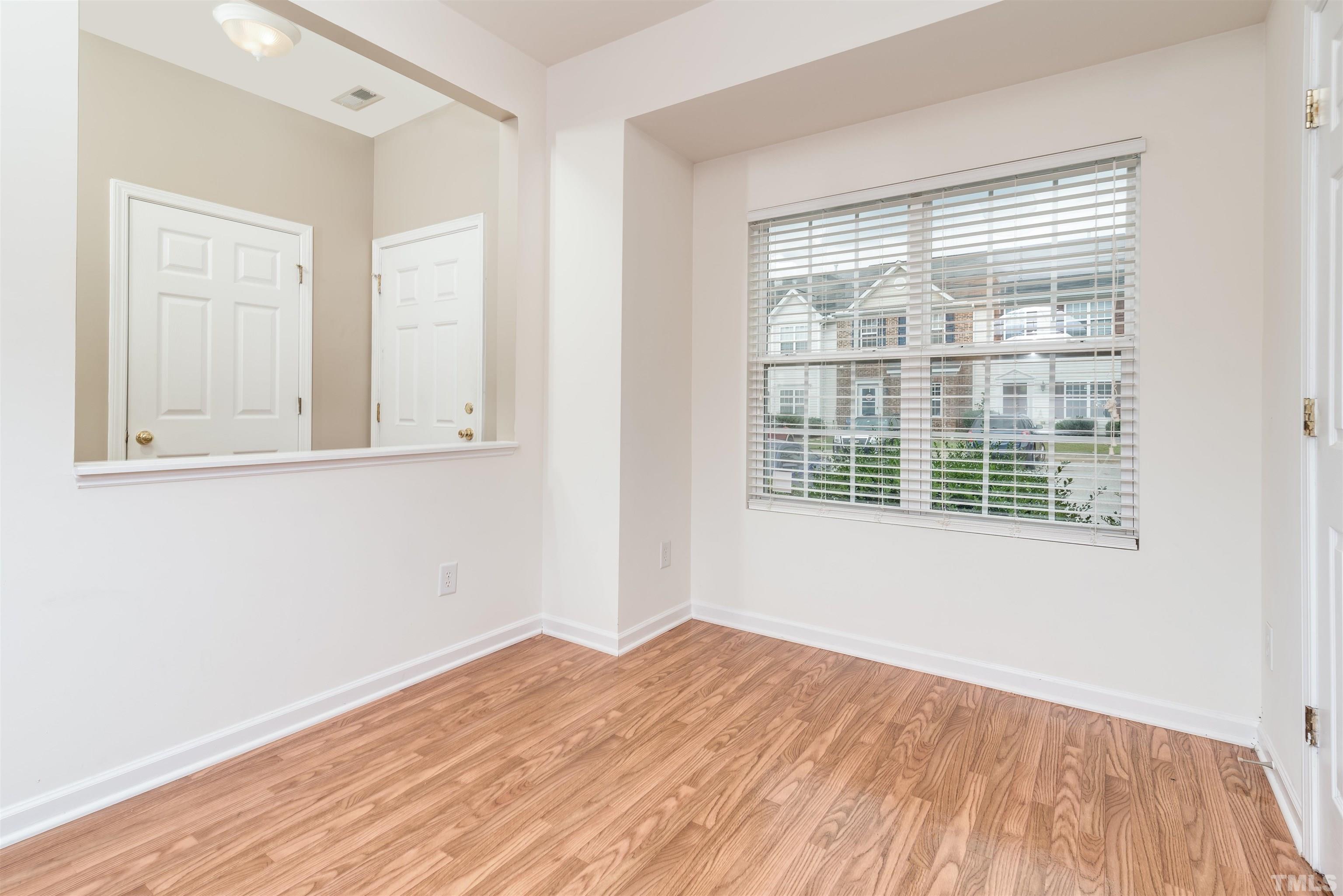 105 Graystar Road Apex, NC 27502 - Photo 11 of 35 a view of an empty room with wooden floor and a window
