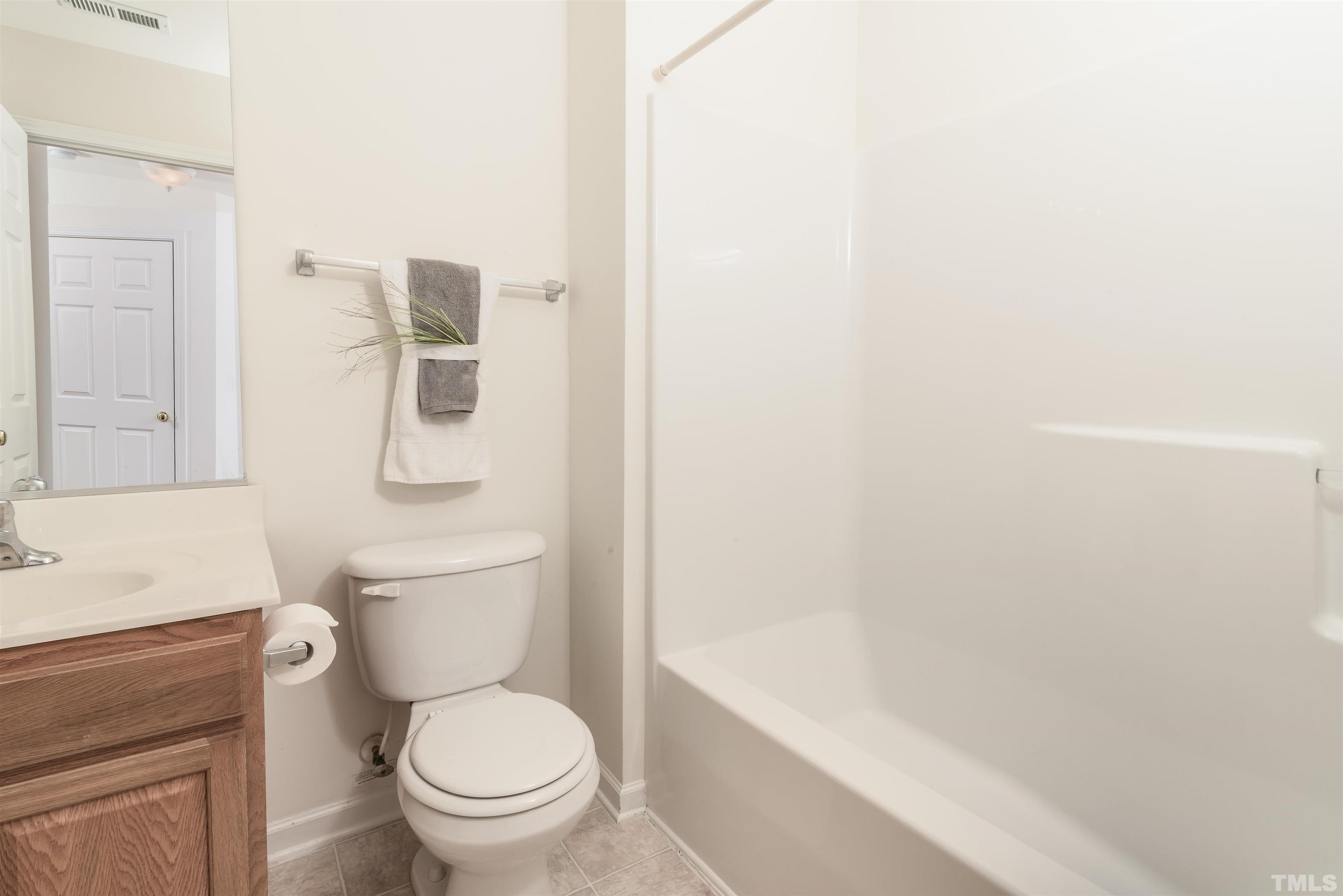 105 Graystar Road Apex, NC 27502 - Photo 24 of 35 a white toilet sitting next to a bathroom sink and vanity